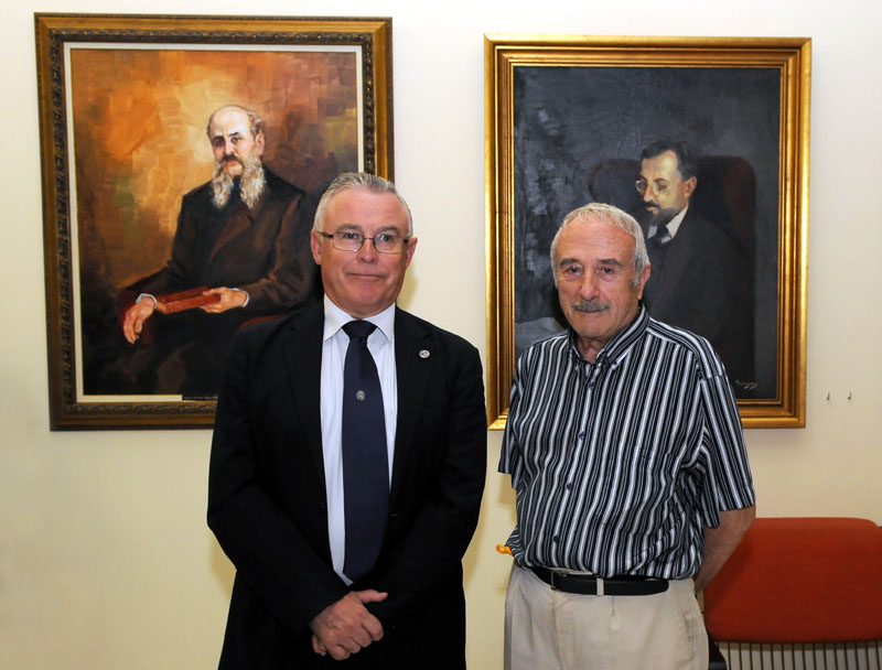 El artista José María Falgas y el rector José Antonio Cobacho posan ante los dos nuevos retratos incorporados a la Galería de rectores.