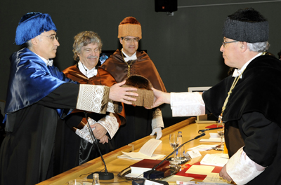 El rector (der) entrega el birrete al padrino, Jesuús García Molina, en presencia de Alan Kay.